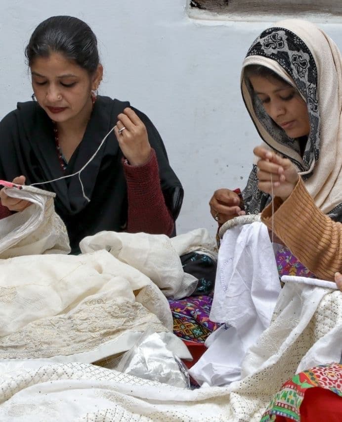 Artisans preparing fine white cotton for embroidery