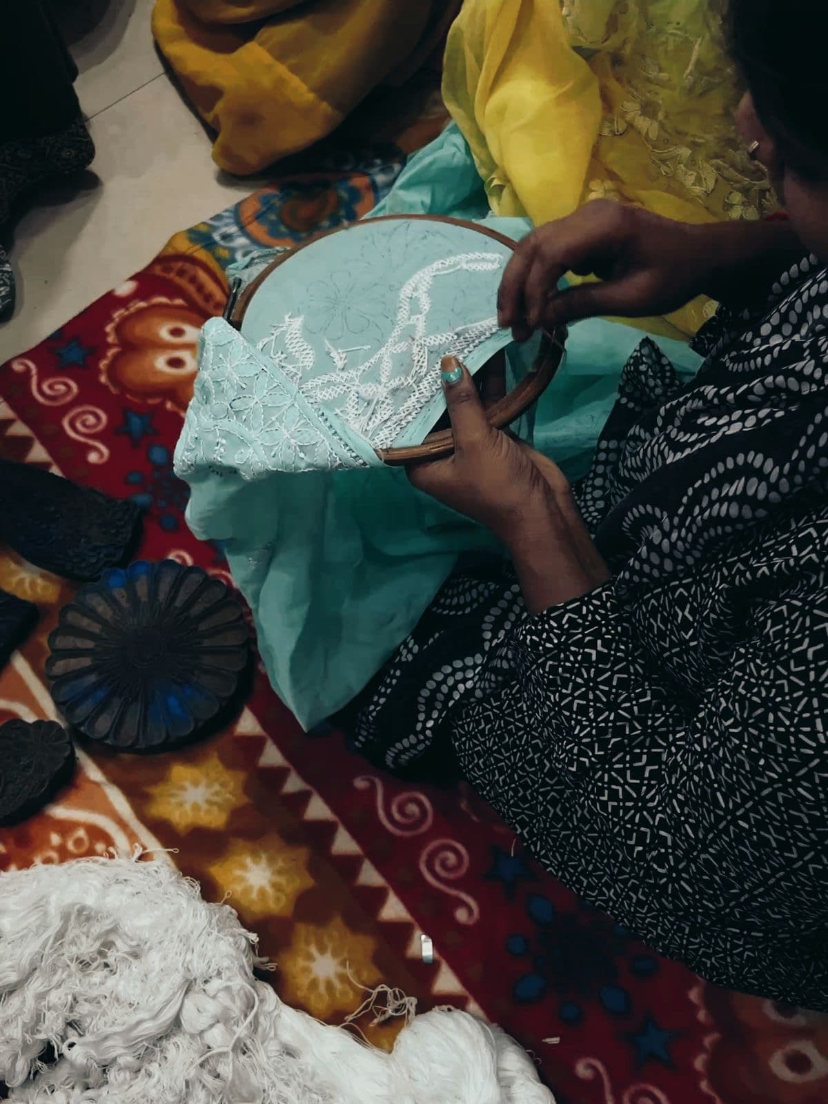 Carved wooden printing blocks beside an artisan at work